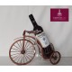 Soporte en forma de bicicleta para botella de vino con copas y rosa.
